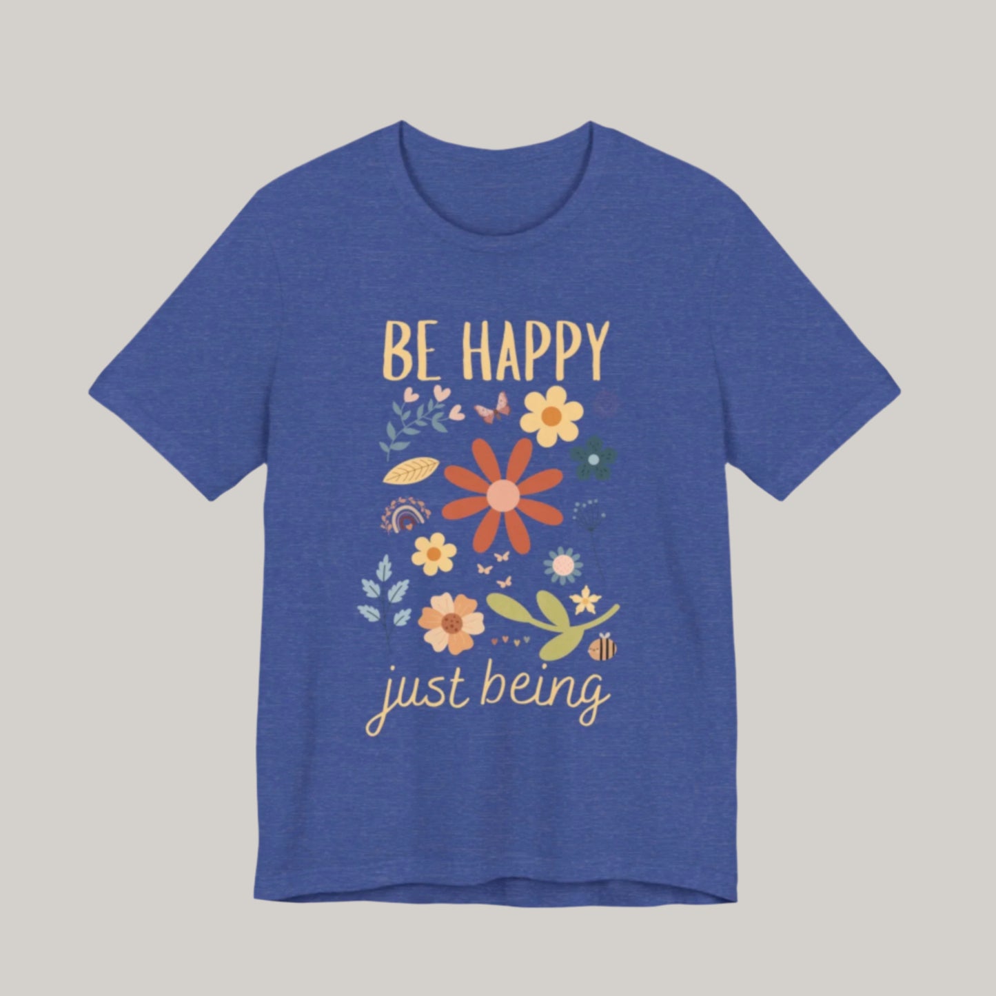 tshirt with the words be happy just being. Design has spring flowers butterflies a rainbow and a bee.