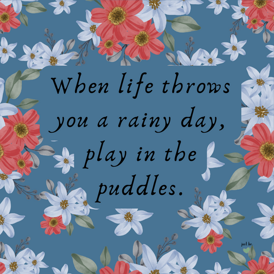 When life throws you a rainy day, play in the puddles quote with cheerful red and white flowers on a blue background